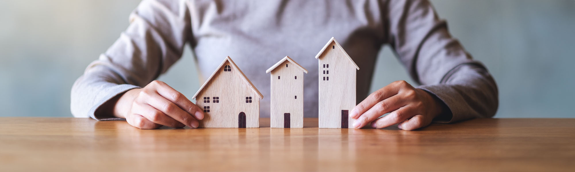 closeup image of a woman holding wooden house models