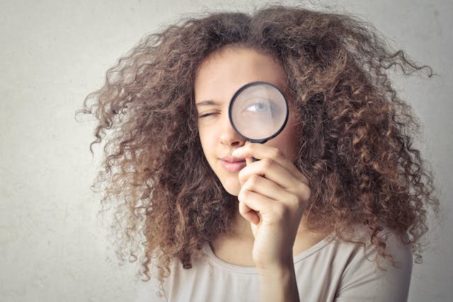 woman holding magnifying glass