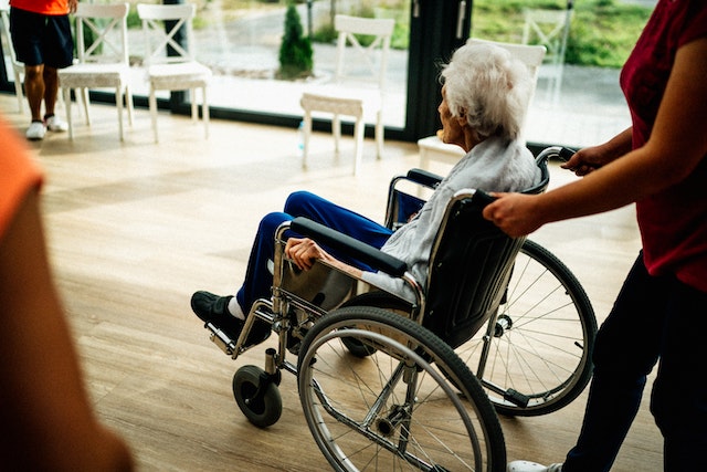 old woman being pushed in wheelchair